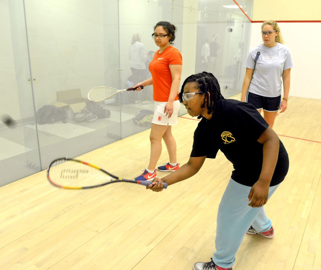 Aniya Mike, at front, a Steel City Squash student from St. Benedict the Moor School in the Hill District, gets instruction at Chatham University from Kathryn Brummer, a tutor/coach visiting from CitySquash in New York City. Bianca Troche, left, is a CitySquash student from Aquinas High School in the Bronx. (Image: Bill Wade/Post-Gazette)